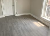 Thumbnail 11 of 13 - A room with a white door and a window with a grey floor.
