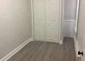 Thumbnail 7 of 13 - A white door with a black handle is in a room with wood flooring.