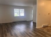 Thumbnail 2 of 7 - A room with wooden flooring and a window.