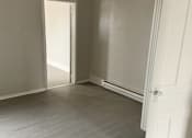 Thumbnail 12 of 13 - A room with a white door and a white wall.