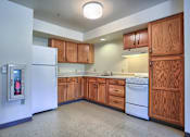 Thumbnail 2 of 2 - a kitchen with white appliances and wooden cabinets