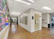 Thumbnail 12 of 18 - a hallway with lockers and a colorful mural on the wall
