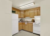 Thumbnail 14 of 18 - a kitchen with white appliances and wooden cabinets
