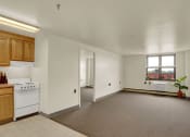 Thumbnail 15 of 18 - a kitchen and living room with white walls and gray carpet