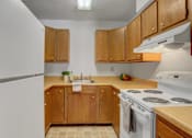 Thumbnail 12 of 15 - a kitchen with wooden cabinets and white appliances