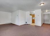 Thumbnail 10 of 15 - an empty living room with a kitchen in the background