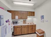 Thumbnail 9 of 14 - a kitchen with wooden cabinets and a white refrigerator