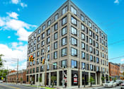 Thumbnail 73 of 73 - A large building with many windows is situated on a street corner.