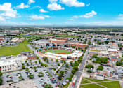 Thumbnail 45 of 73 - A large stadium is surrounded by buildings in the center of a town.