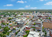 Thumbnail 43 of 73 - A cityscape with buildings of various sizes and shapes, surrounded by greenery.