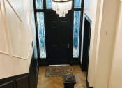 Thumbnail 21 of 26 - a stairway with a chandelier and a black door