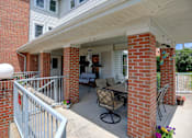 Thumbnail 3 of 16 - a patio with a table and chairs in front of a house