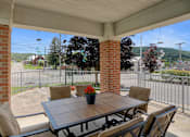 Thumbnail 4 of 16 - a patio with a wooden table and chairs with a potted plant on it