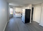 Thumbnail 15 of 23 - A kitchen with a black fridge and white cabinets.