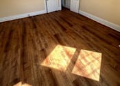 Thumbnail 13 of 23 - A room with wooden floors and two white doors.
