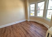 Thumbnail 12 of 23 - A room with wooden floors and a window overlooking a street.
