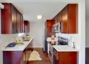 Thumbnail 1 of 18 - a kitchen with wooden cabinets and white counter tops and a stainless steel refrigerator