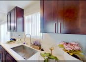 Thumbnail 4 of 18 - a kitchen with a sink and wooden cabinets