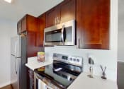 Thumbnail 5 of 18 - a kitchen with stainless steel appliances and wood cabinets