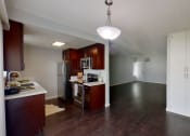 Thumbnail 2 of 18 - an empty kitchen and living room with wood flooring and white walls
