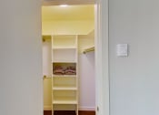 Thumbnail 11 of 18 - a walk in closet with shelves and a white door