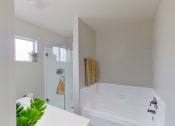 Thumbnail 12 of 18 - a white bathroom with a large tub and a shower