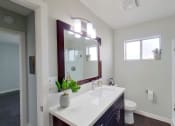 Thumbnail 7 of 18 - a bathroom with a sink and a mirror and a toilet