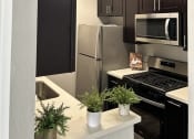 Thumbnail 16 of 54 - a kitchen with stainless steel appliances and black and white cabinets