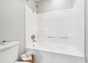 Thumbnail 58 of 59 - A white bathroom with a white tub and a white sink.