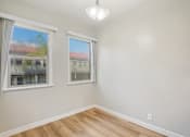 Thumbnail 15 of 51 - A room with two windows and a wooden floor.