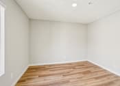 Thumbnail 62 of 66 - A room with wooden flooring and white walls.
