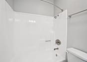 Thumbnail 53 of 53 - A white bathroom with a toilet and a shower.
