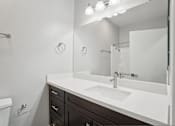 Thumbnail 50 of 53 - A white sink in a bathroom with a mirror above it.