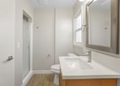 Thumbnail 8 of 64 - A white bathroom with a toilet, sink, and mirror.