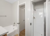 Thumbnail 60 of 64 - A white bathroom with a tub and shower.