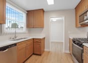 Thumbnail 7 of 64 - A kitchen with wooden cabinets and stainless steel appliances.