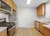 Thumbnail 55 of 64 - A kitchen with wooden cabinets and a white door.