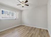 Thumbnail 39 of 49 - A room with a ceiling fan and wooden flooring.