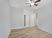 Thumbnail 40 of 49 - A room with a ceiling fan and wooden flooring.