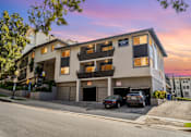 Thumbnail 29 of 49 - A building with a parking lot in front of it.