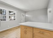 Thumbnail 47 of 49 - A kitchen with wooden cabinets and a white countertop.