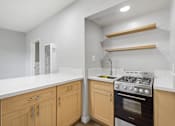 Thumbnail 33 of 49 - A kitchen with a white countertop and wooden cabinets.