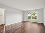 Thumbnail 36 of 64 - A room with a window and wooden flooring.