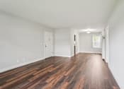 Thumbnail 37 of 64 - A room with wooden floors and white walls.
