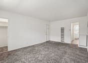 Thumbnail 22 of 40 - A large empty room with a grey carpet.