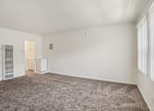 Thumbnail 24 of 40 - A room with a carpeted floor and a window with blinds.