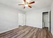 Thumbnail 14 of 42 - A room with a ceiling fan and wooden flooring.