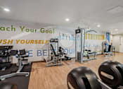 Thumbnail 24 of 53 - A gym with a variety of equipment and motivational phrases on the wall.