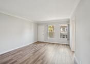 Thumbnail 13 of 51 - A room with a wooden floor and white walls.
