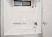Thumbnail 59 of 59 - A white bathroom with a shower and a bathtub.